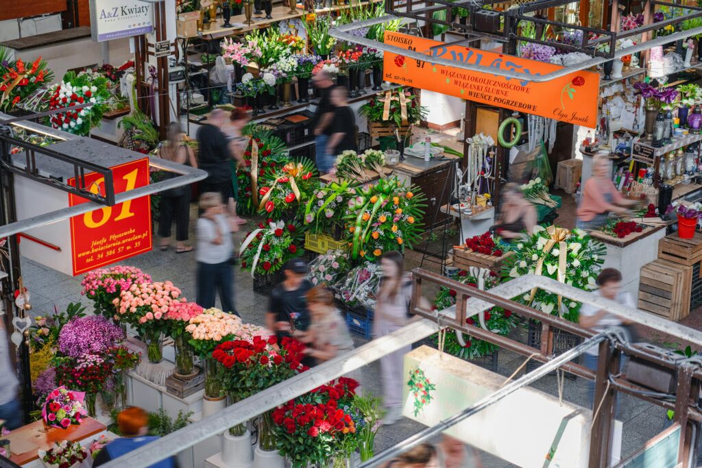 Capture of Wrocław's bustling flower market showcasing vibrant floral arrangements and shoppers.