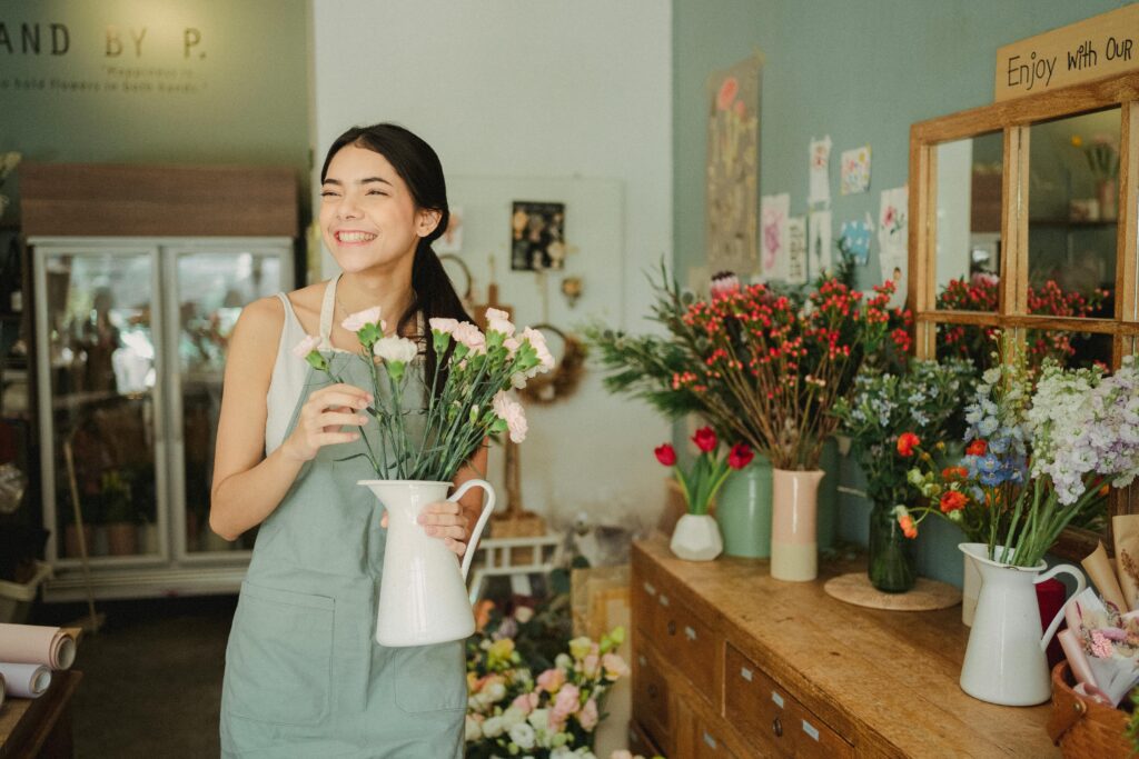 A joyful florist arranges fresh blooms in a charming flower shop.